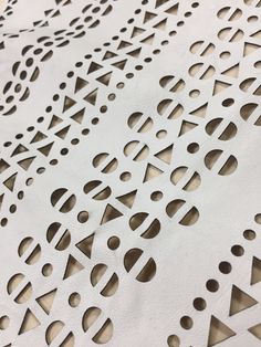 a close up view of an intricately designed piece of paper with holes in it