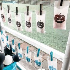 there are many bags hanging on the line with pumpkins and jack - o'- lanterns