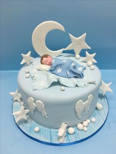 a baby is sleeping on top of a blue cake with stars and moon decorations around it