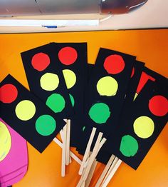 four black and green polka dot stickers on top of a yellow table next to a pair of scissors