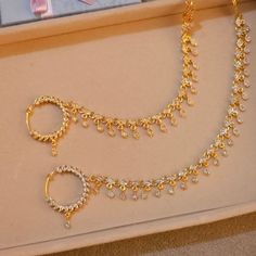 three gold necklaces and earrings on display in a box