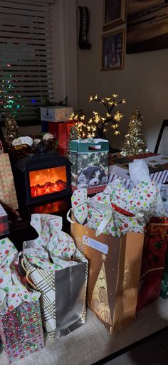 many wrapped presents sitting on a table in front of a fireplace