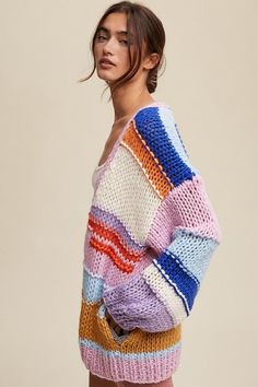 a woman is wearing a multicolored sweater and shorts