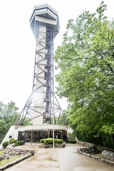 a tall tower sitting next to a lush green forest