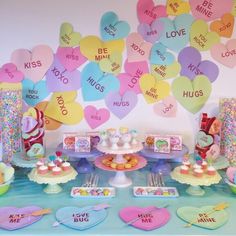 a table topped with lots of heart shaped balloons and desserts covered in confetti