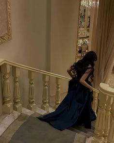 a woman in a black dress is standing on the stairs