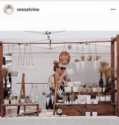 a woman standing in front of a table filled with pots and planters next to a sign that says, layers & height