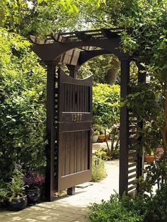 a wooden gate surrounded by plants and trees