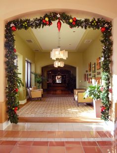 an archway decorated with christmas decorations and greenery