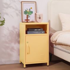 a small yellow cabinet next to a bed