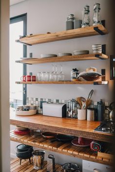 the shelves in this kitchen are filled with pots, pans and utensils