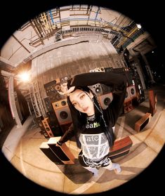 a woman sitting on the ground in front of some speakers