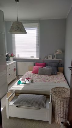 a bedroom with a bed, dresser and window