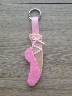 a keychain made out of felt with a pink shoe hanging from it's side