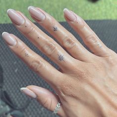 a woman's hand with some nail polish on it and a ring in the middle