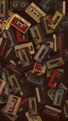 a pile of old cassettes sitting on top of each other in different colors and sizes