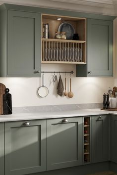 a kitchen with green cabinets and white counter tops