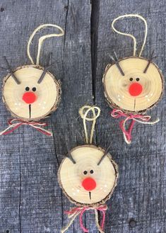 three wood slices with faces and noses on them, tied together in twine to each other