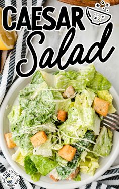 a white bowl filled with lettuce and croutons on top of a table