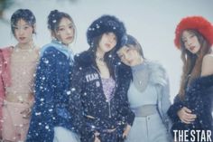 four girls standing in the snow wearing jackets and hats