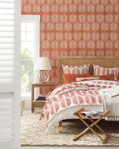 a bedroom with an orange and white wallpaper