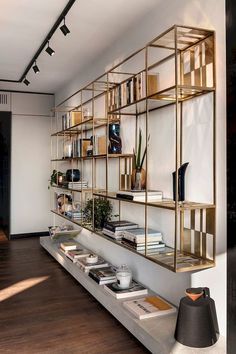 a bookshelf filled with lots of books next to a wall mounted shelf full of books