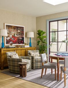 a living room filled with furniture and a painting on the wall over a dining table