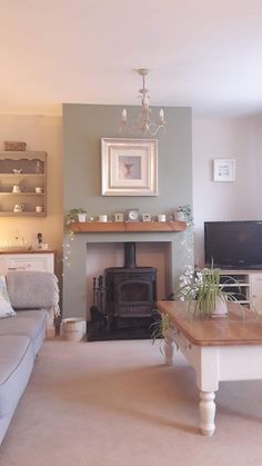 a living room filled with furniture and a fire place next to a wall mounted tv