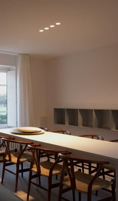 a dining room table and chairs in front of a window