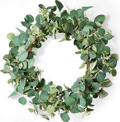 a wreath with green leaves and white flowers