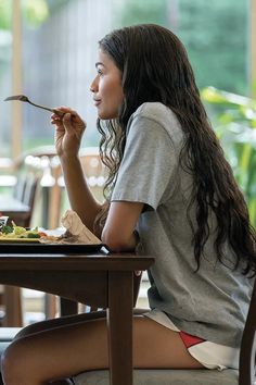 a woman sitting at a table eating food