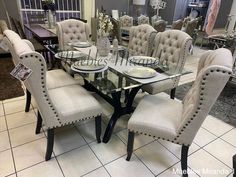 a dining room table with chairs and plates on it in front of a store display