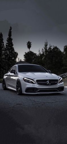 the front end of a white mercedes s - class coupe parked on a road at night