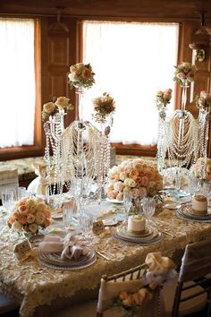 the table is set for a formal function with flowers and candles on top of it