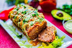 the meatloaf is cut into slices and served with avocado on the side