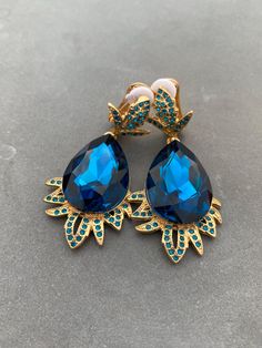 Elevate your style with these stunning Oscar De La Renta clip-on earrings. The gold-plated design features blue crystals that add a pop of color to any outfit. Perfect for a night out or special occasion, these dangle/drop earrings make a statement.  Add them to your collection today and make a fashion statement. Sold without original packing international shipping from 20 days to 2 months to USA. 2-3 weeks to EU Most of the times, it arrived within 25 days, but sometimes it could be delayed as Daughter Best Friend, Luxury Birthday, Earrings Luxury, New Year Gift, Nouvel An, Blue Crystals, New Year Gifts, Mother Daughter, Clip On