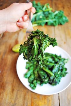 a person is cutting up some broccoli on a plate