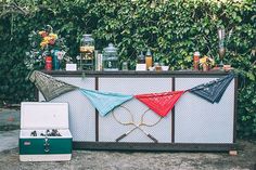 an outdoor bar is decorated with red, white and blue items in front of green bushes