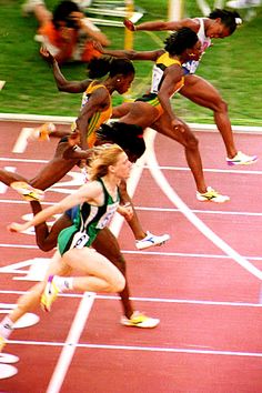 a group of women running on top of a race track