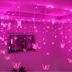 pink lights hanging from the ceiling in a room with butterflies on it and a mirror