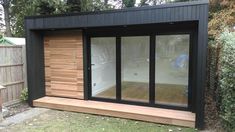 a small black building with sliding glass doors