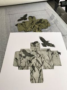 paper cut out with birds and flowers on top of the floor next to each other