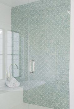 a white bathroom with a glass shower door