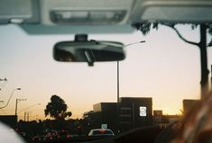 the sun is setting in the distance as seen from inside a vehicle's side view mirror