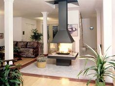 a living room filled with furniture and a fire place in the middle of an open floor plan