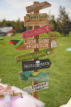 a wooden sign that has many different signs on it