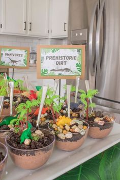 there are many potted plants on the counter in front of the refrigerator and sign