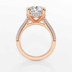 a rose gold engagement ring with a cushion cut diamond on the side and pave set shoulders