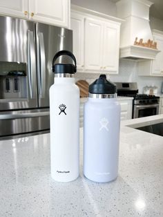 two water bottles sitting on top of a kitchen counter