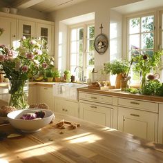 a kitchen filled with lots of counter top space next to a bowl of vegetables and flowers